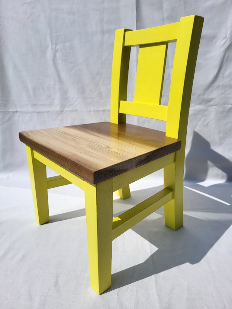 Modern yellow wooden chair against a white background