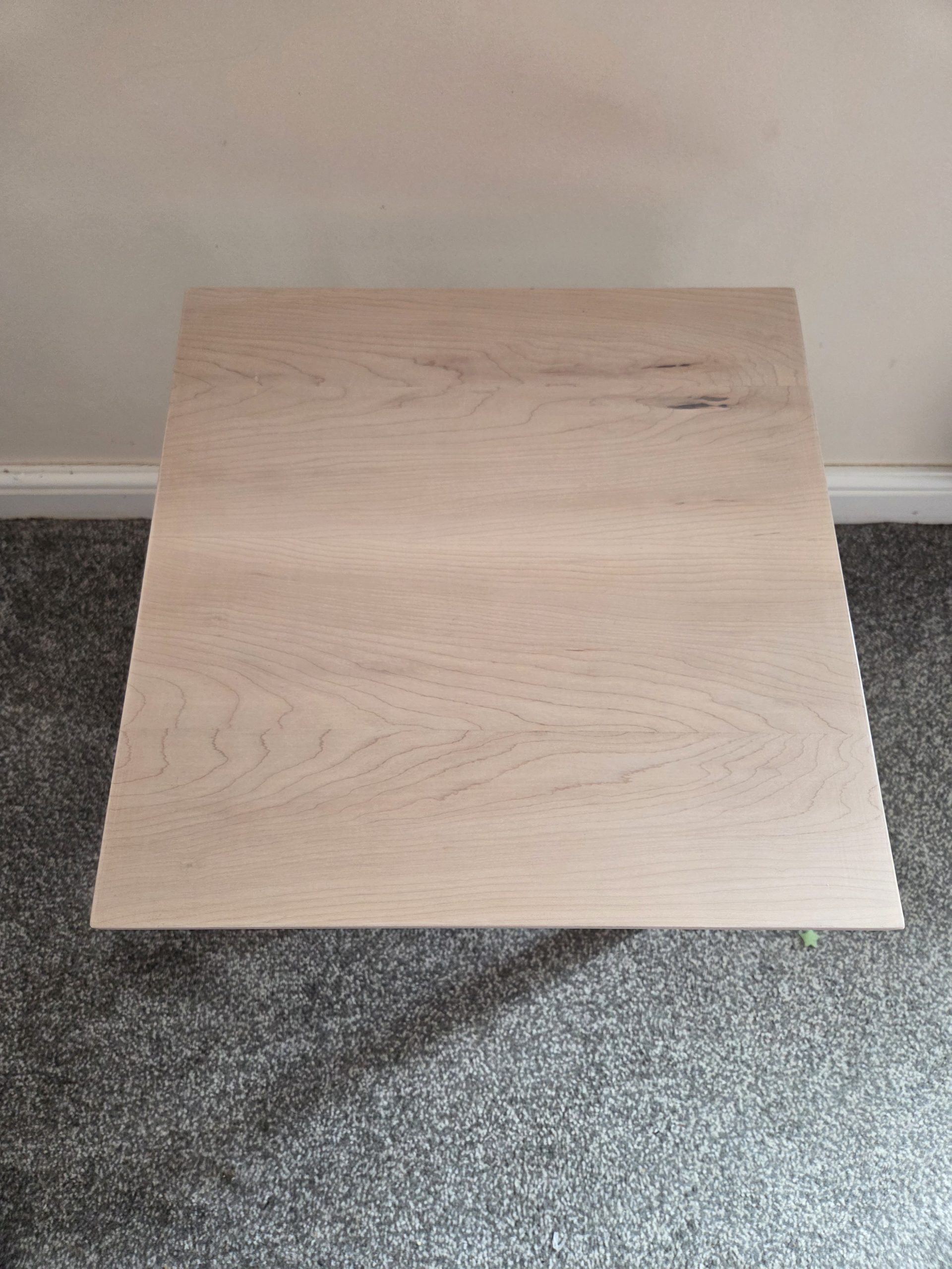 Artisan-crafted wooden tabletop with a light natural finish, showcasing elegant grain patterns, organic knots, and subtle tonal variations. Made from sustainably sourced timber, this piece blends timeless design with authentic craftsmanship—ideal for interiors that value warmth, character, and quality.